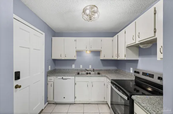 a kitchen with white cabinets and appliances