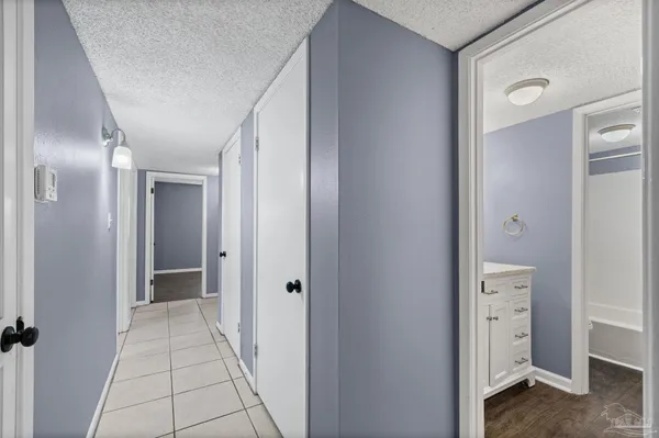an empty room with wooden floor chandelier fan and closet area