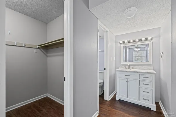 an empty room with wooden floor ceiling fan and windows