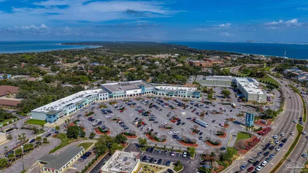 an aerial view of ocean and residential houses with outdoor space