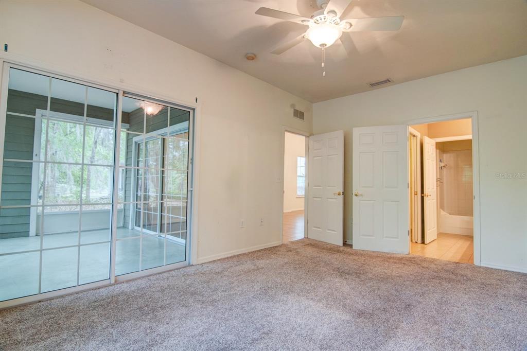 1563 Northwest 29 Road, Unit 108 Gainesville, FL 32605 - Photo 18 of 25 en empty room with windows and ceiling fan