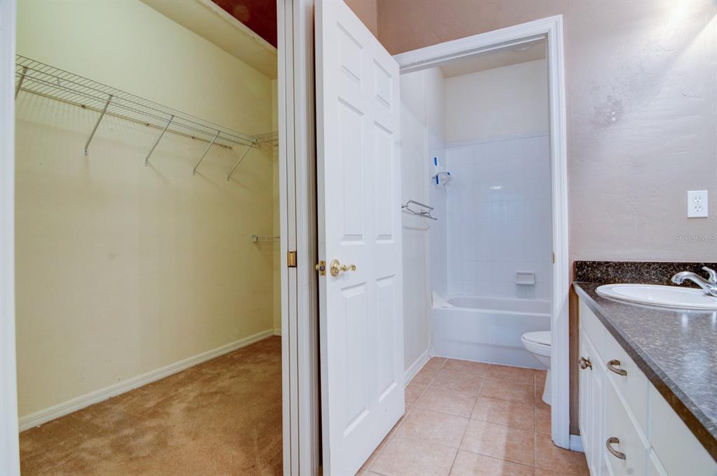 1563 Northwest 29 Road, Unit 108 Gainesville, FL 32605 - Photo 19 of 25 a bathroom with a granite countertop sink a toilet and shower