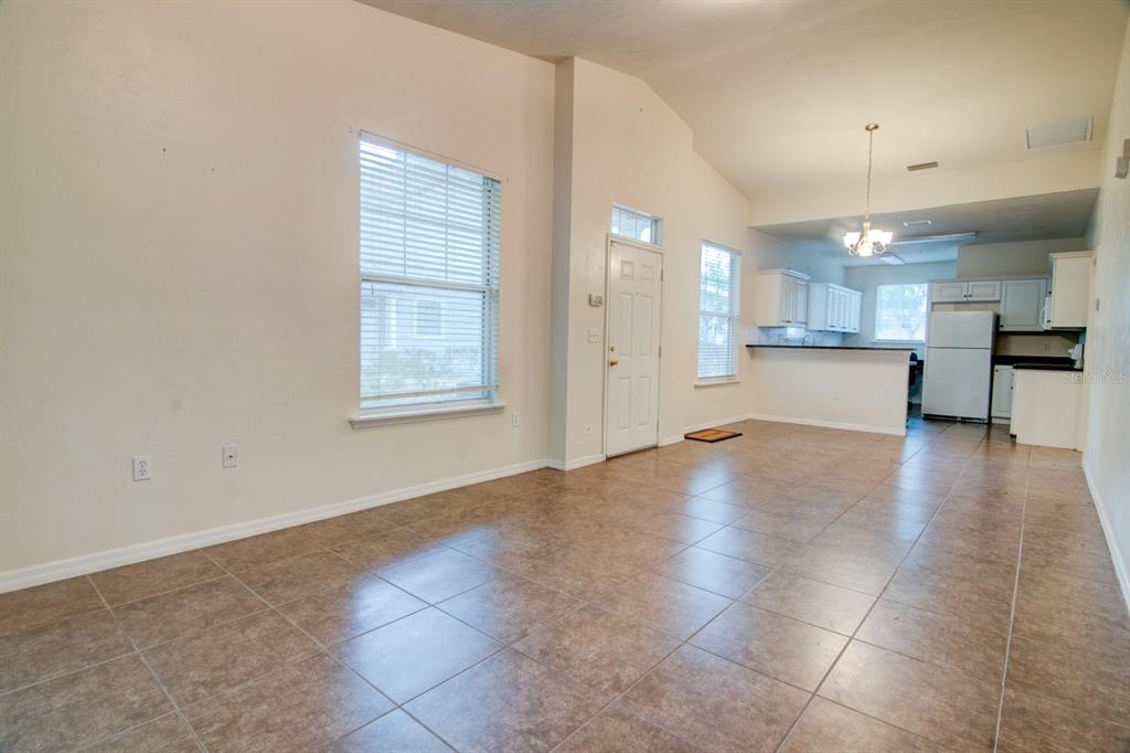 1563 Northwest 29 Road, Unit 108 Gainesville, FL 32605 - Photo 4 of 25 an empty room with kitchen and windows
