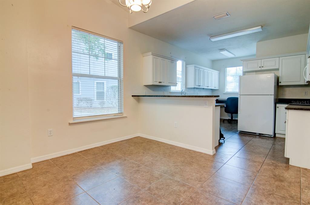 1563 Northwest 29 Road, Unit 108 Gainesville, FL 32605 - Photo 6 of 25 a kitchen with stainless steel appliances granite countertop a refrigerator sink and cabinets