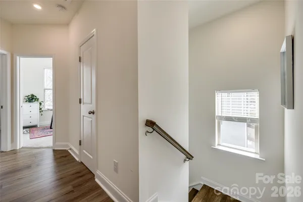 a view of hallway with wooden floor and windows