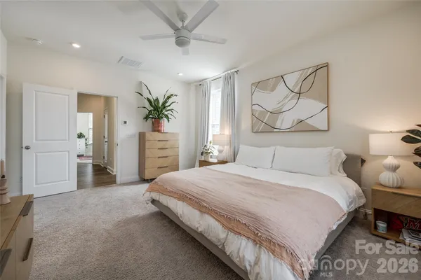 a spacious bedroom with a bed and a chandelier