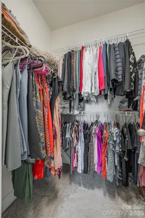 a view of walk in closet with clothes