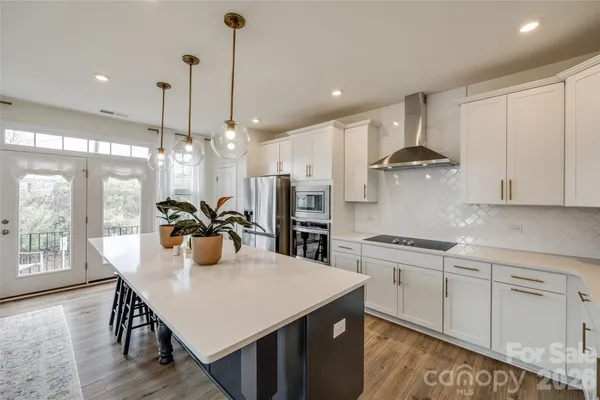 a kitchen with stainless steel appliances granite countertop a sink a stove a refrigerator and island