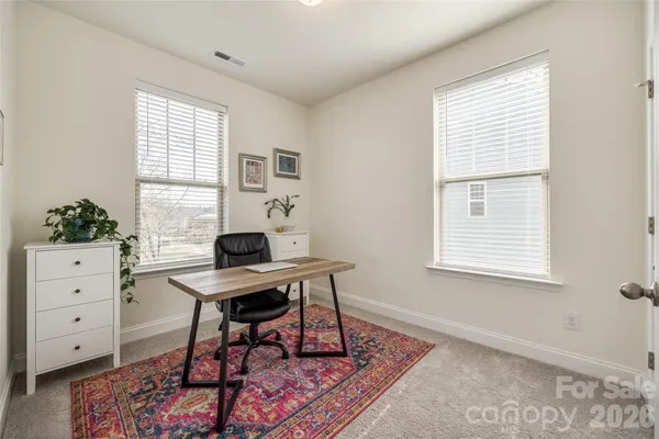 a view of a workspace with furniture and a window