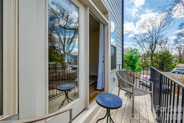 a view of a balcony with chairs and a potted plant