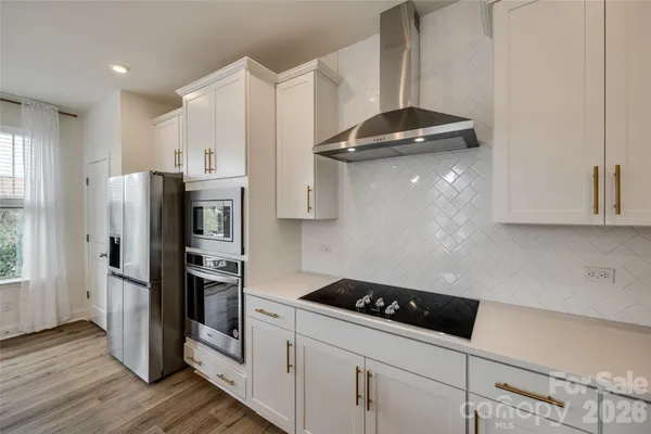 a kitchen with stainless steel appliances a refrigerator and a stove top oven