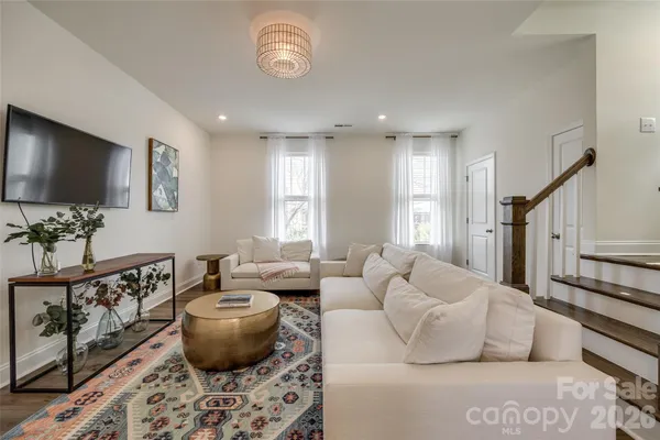 a living room with furniture a flat screen tv and a large window