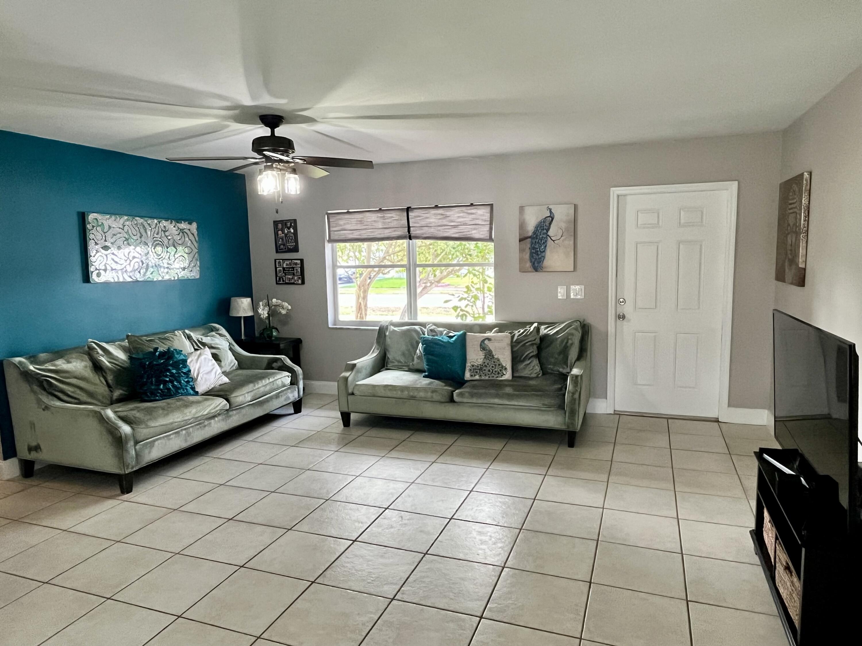 4730 Betelnut Street Boca Raton, FL 33428 - Photo 13 of 42 a living room with furniture and a flat screen tv