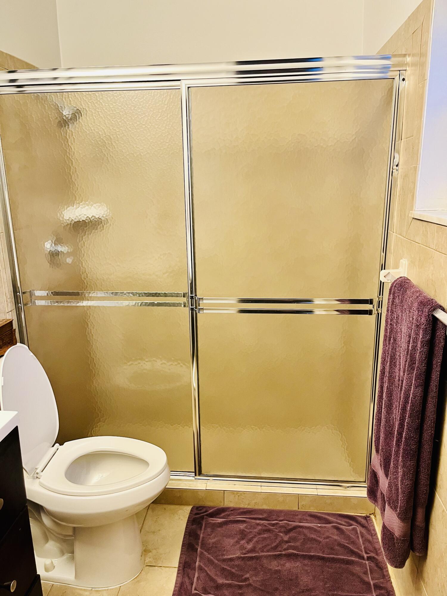 4730 Betelnut Street Boca Raton, FL 33428 - Photo 20 of 42 a bathroom with a shower a toilet and a shower