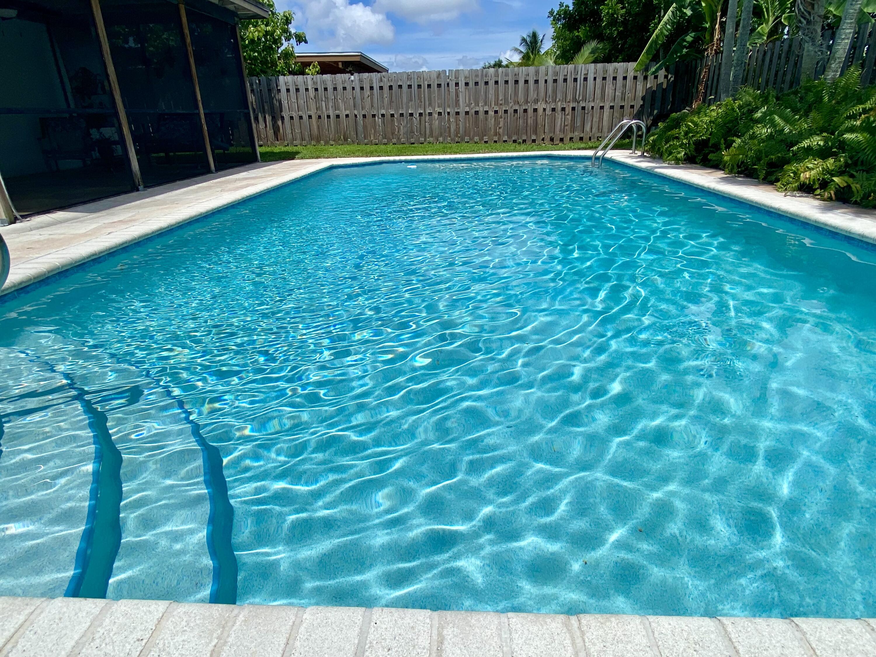 4730 Betelnut Street Boca Raton, FL 33428 - Photo 2 of 42 a view of backyard with swimming pool and wooden fence