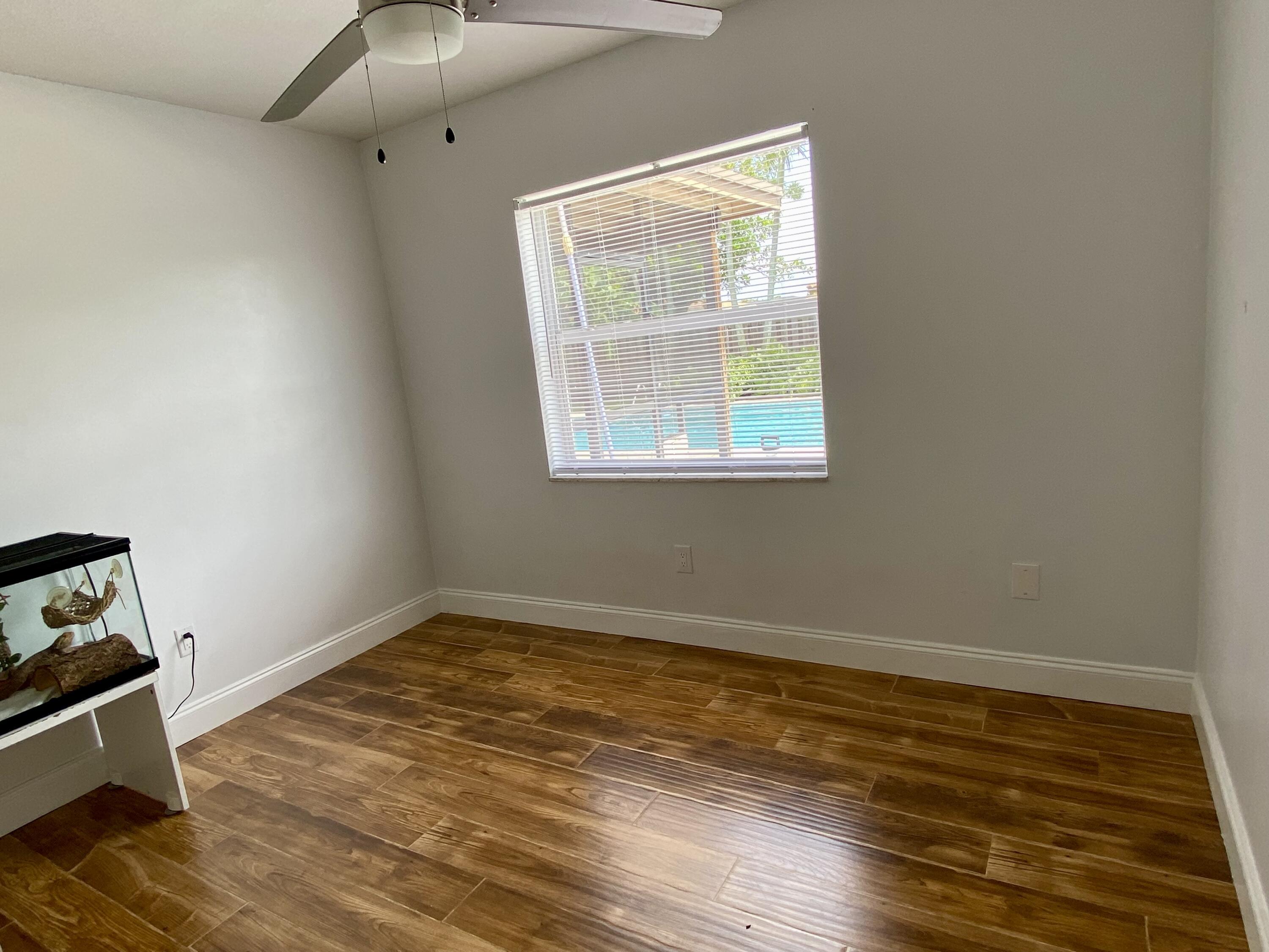 4730 Betelnut Street Boca Raton, FL 33428 - Photo 26 of 42 a view of an empty room with wooden floor and a window