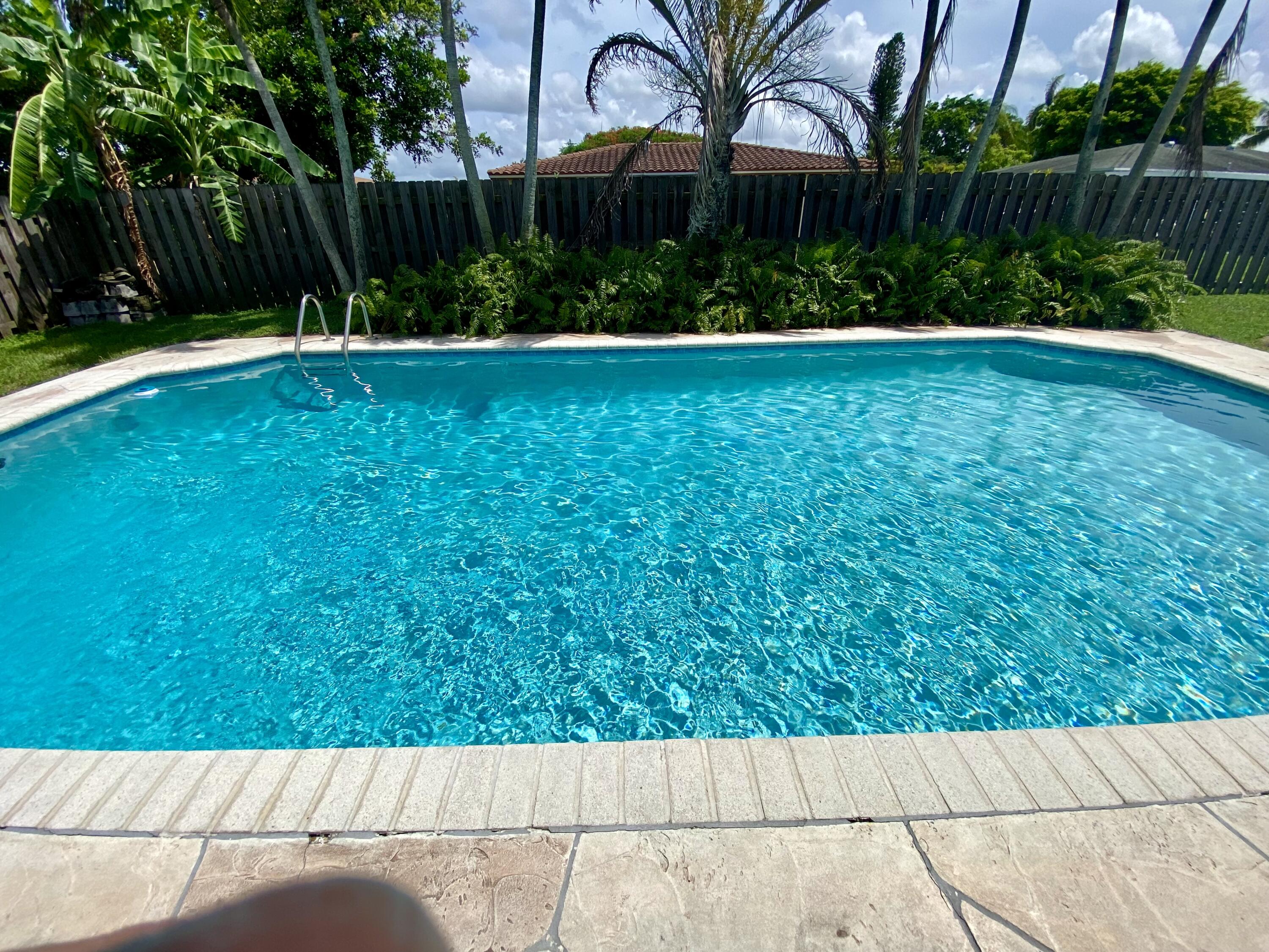 4730 Betelnut Street Boca Raton, FL 33428 - Photo 29 of 42 a view of backyard with potted plants and wooden fence