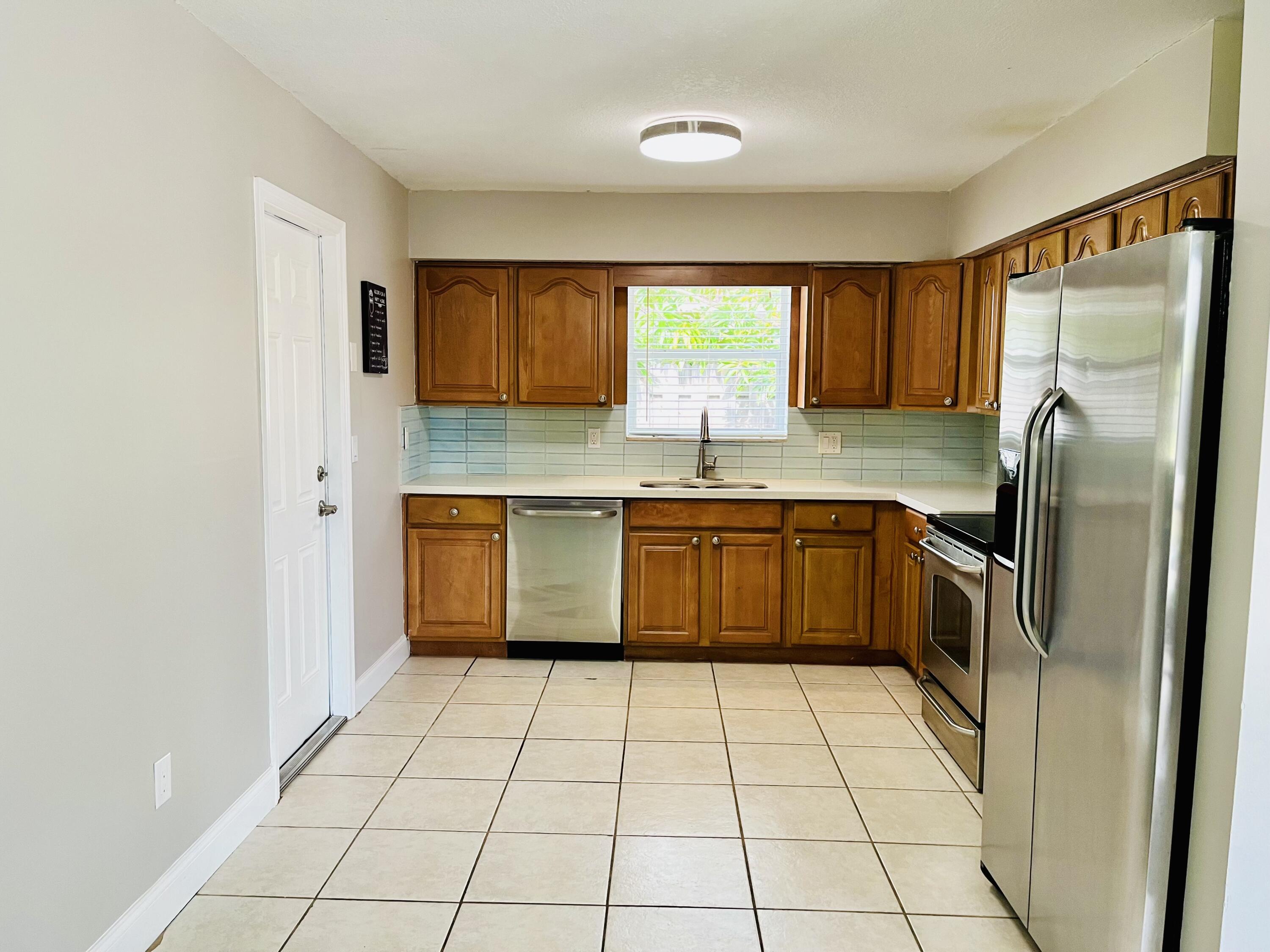 4730 Betelnut Street Boca Raton, FL 33428 - Photo 9 of 42 a kitchen with stainless steel appliances granite countertop a stove a sink dishwasher and a refrigerator