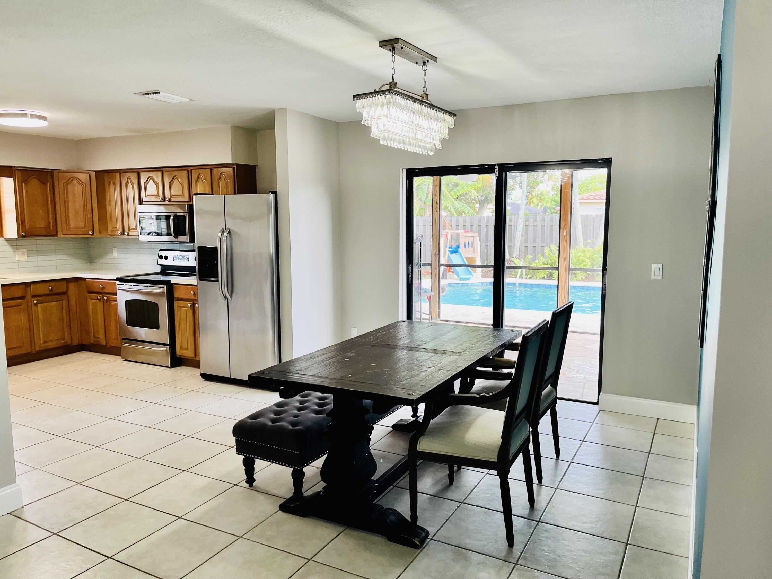 4730 Betelnut Street Boca Raton, FL 33428 - Photo 10 of 42 a view of a dining room with furniture and a chandelier