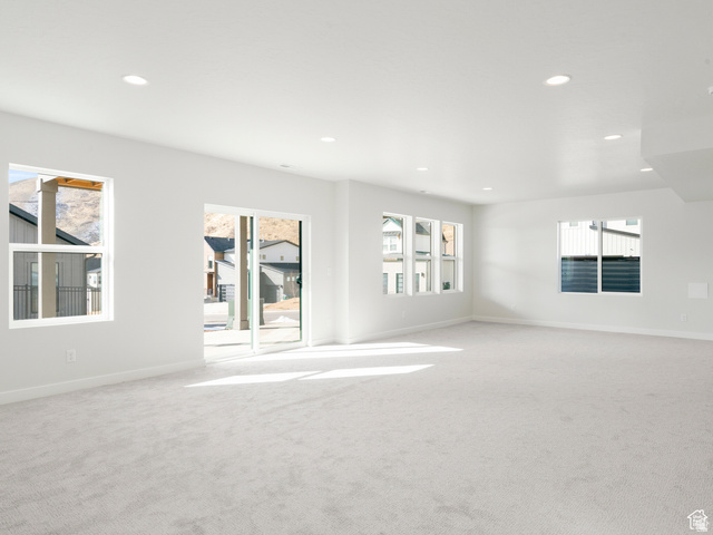 1711 West Canyon Rim Road North Lehi, UT 84048 - Photo 22 of 31 Spacious room featuring light gray carpeting, crisp white walls, recessed ceiling lighting, and multiple windows including a sliding glass door
