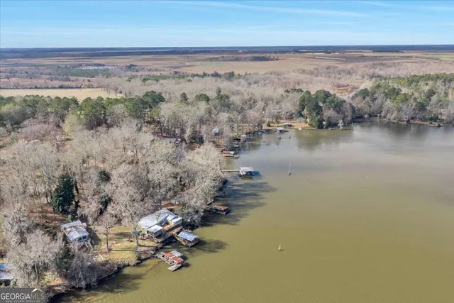 a kitchen with stainless steel appliances kitchen island granite countertop a table chairs in it and wooden floors