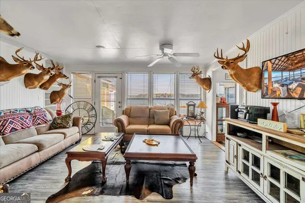 a living room with stainless steel appliances furniture and a flat screen tv