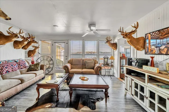a living room with stainless steel appliances furniture and a flat screen tv