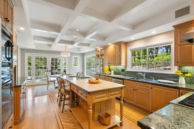 a dining room with stainless steel appliances kitchen island granite countertop a table chairs and a refrigerator