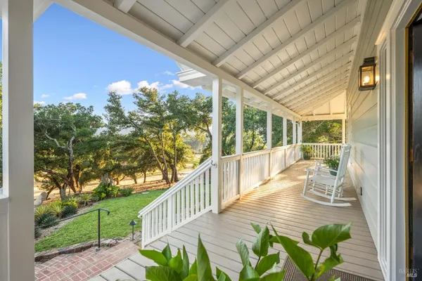 a view of a porch with furniture and garden