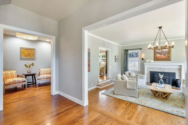a living room with furniture a chandelier and a fireplace