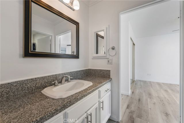 a bathroom with a granite countertop sink a mirror and vanity