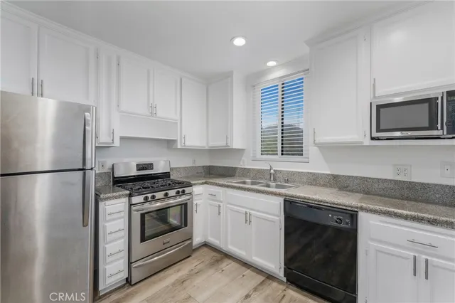a kitchen with white cabinets and white appliances