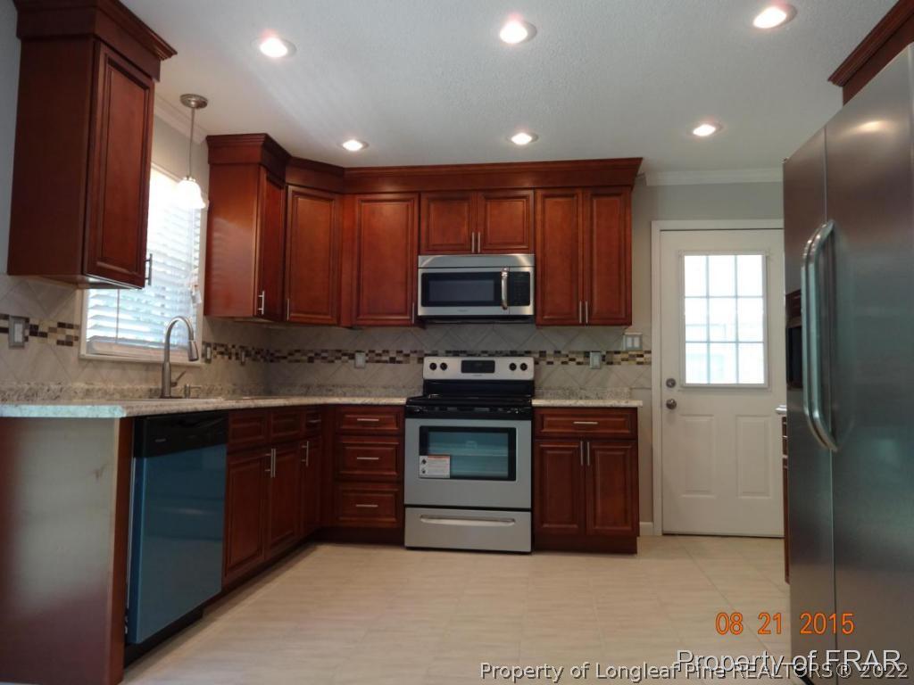 414 Lansdowne Road Fayetteville, NC 28314 - Photo 3 of 14 a kitchen with stainless steel appliances granite countertop a stove a sink and a microwave