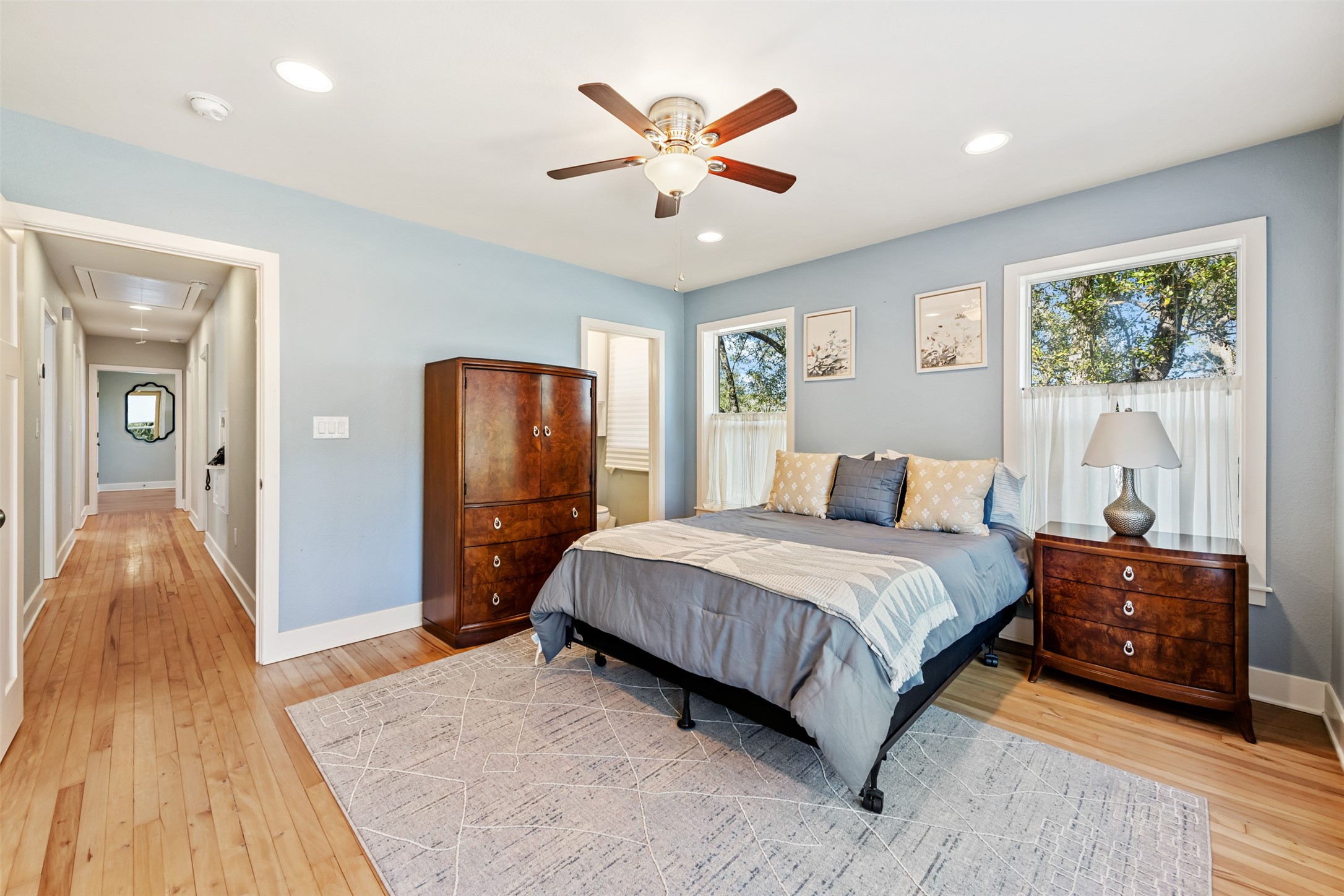 1610 Pace Bend Road North Spicewood, TX 78669 - Photo 9 of 32 a spacious bedroom with a bed and a chandelier