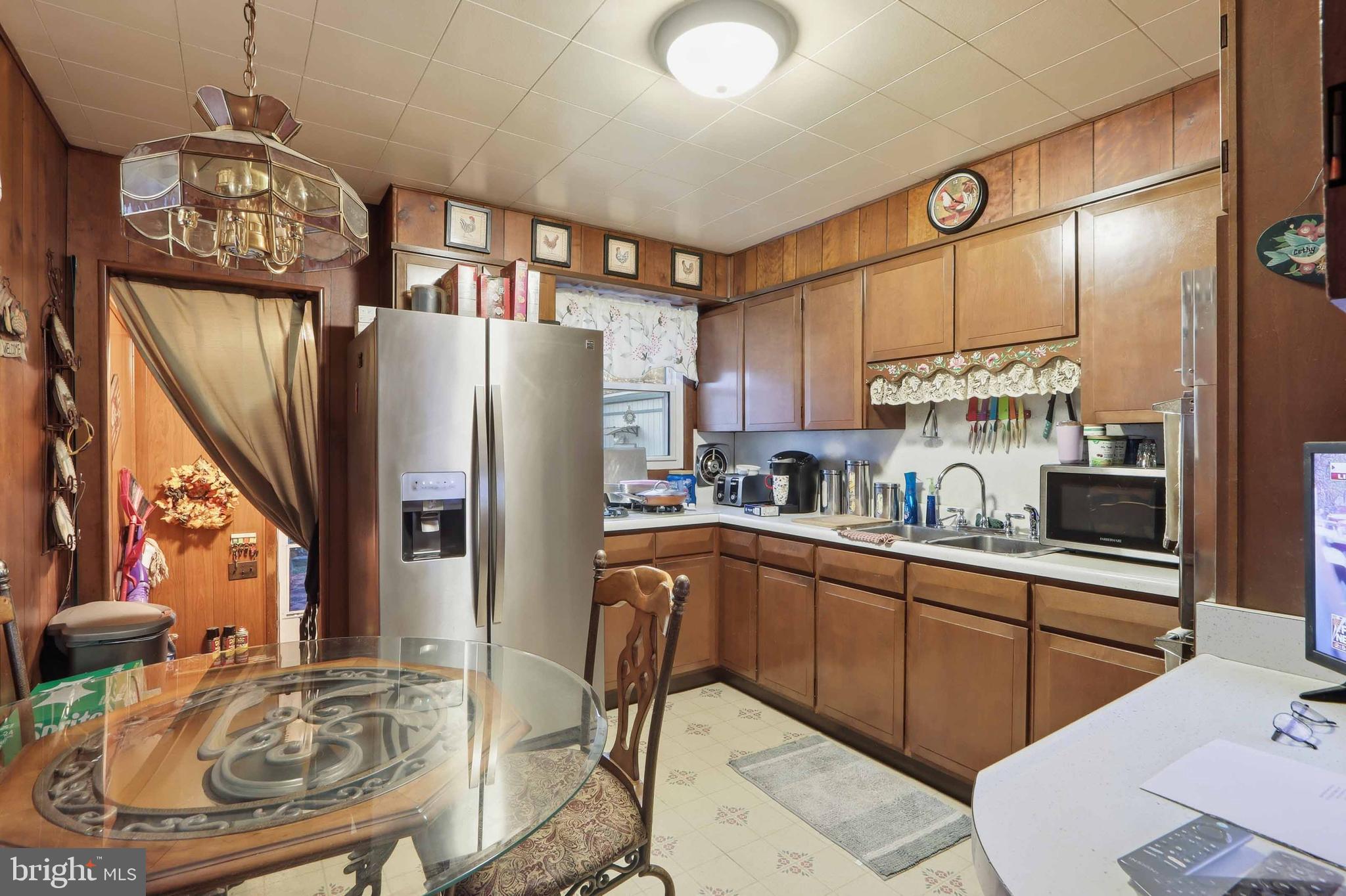 153 Wilgate Road Owings Mills, MD 21117 - Photo 5 of 22 a kitchen with stainless steel appliances granite countertop a refrigerator a sink dishwasher a dining table and chairs with wooden floor