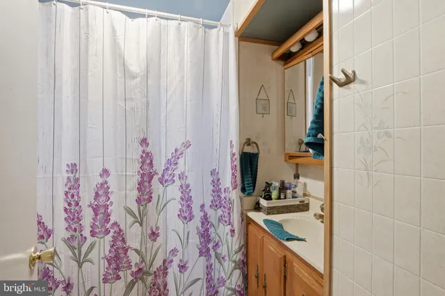 a bathroom with a granite countertop sink a mirror and shower curtain