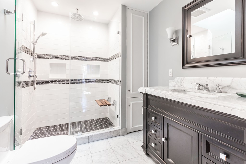 193 Beacon Street, Unit 4 Boston, MA 02116 - Photo 14 of 22 a bathroom with a granite countertop sink a toilet a mirror and shower