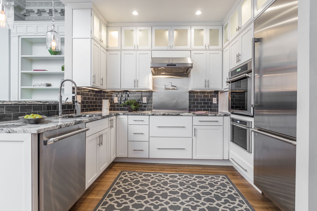 193 Beacon Street, Unit 4 Boston, MA 02116 - Photo 6 of 22 a kitchen with white cabinets and stainless steel appliances