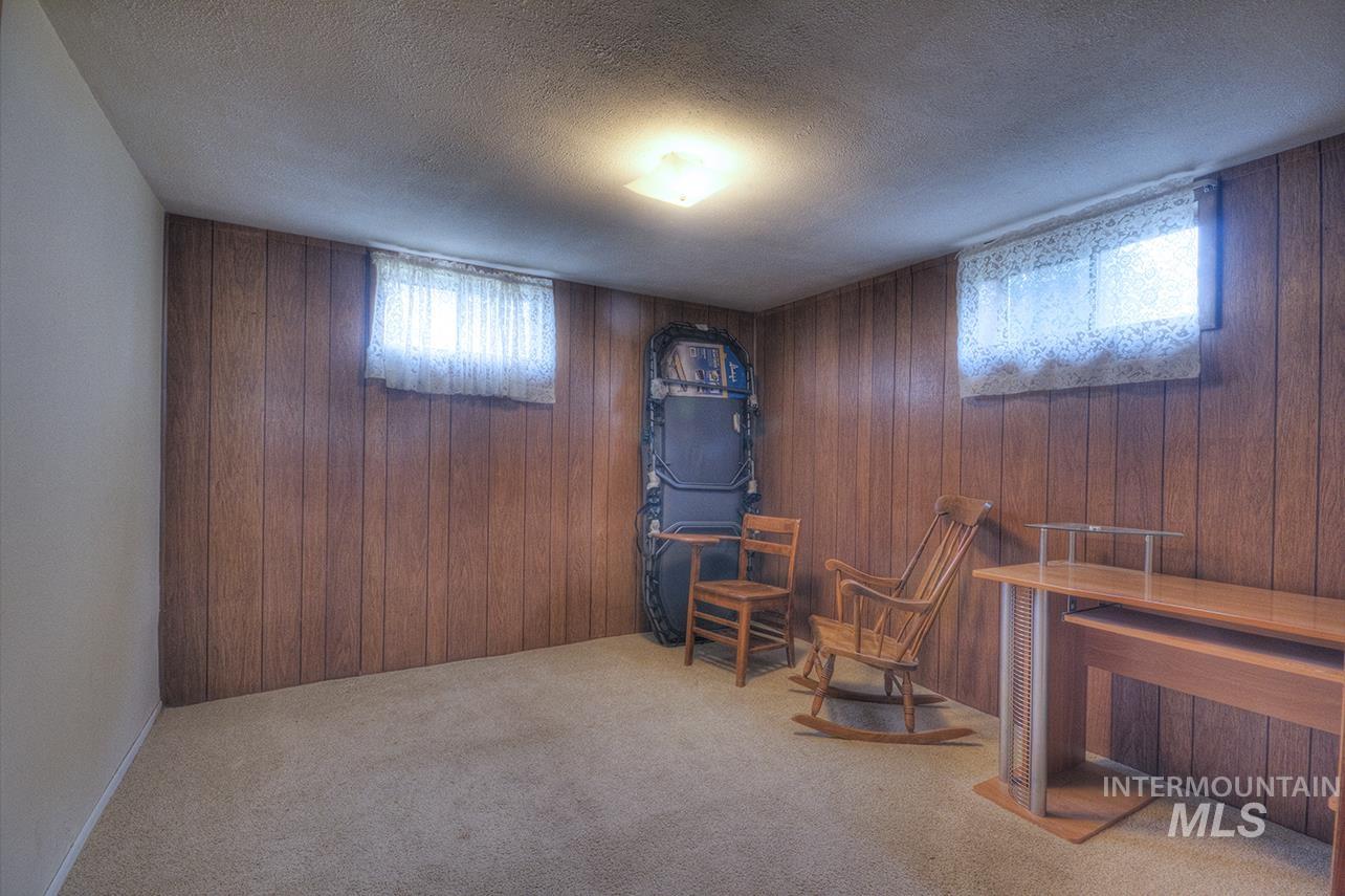 351 West Main Street South Vale, OR 97918 - Photo 13 of 33 Room featuring wood paneling, two windows with textile coverings, and a carpeted floor (no egress/ingress assessor has classified as a bedroom)