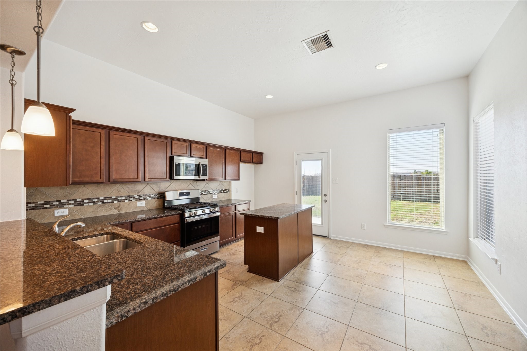8115 Aleppo Pine Lane Cypress, TX 77433 - Photo 13 of 32 a large kitchen with stainless steel appliances granite countertop a stove and a sink