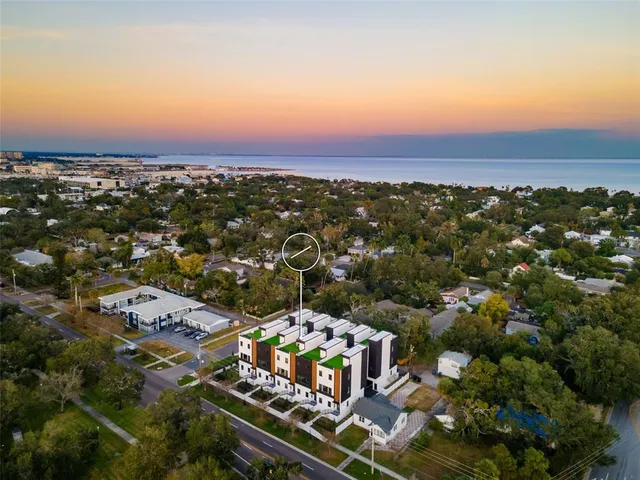 an aerial view of residential houses with outdoor space and parking