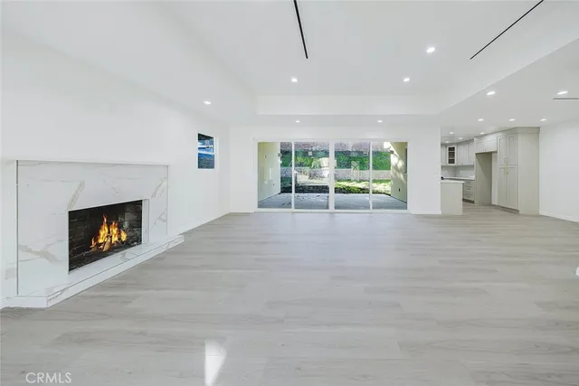 a view of an empty room with a fireplace and a window
