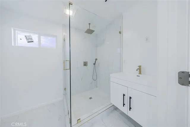 a view of a room with a ceiling fan and wooden floor