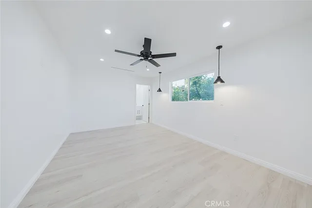 an empty room with windows and fan