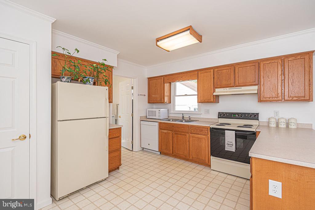 36130 Richland Road Willards, MD 21874 - Photo 11 of 42 a kitchen with granite countertop a refrigerator stove top oven a sink and dishwasher