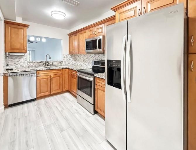 4182 South Pine Island Road Davie, FL 33328 - Photo 2 of 6 a kitchen with stainless steel appliances granite countertop a stove top oven microwave and refrigerator