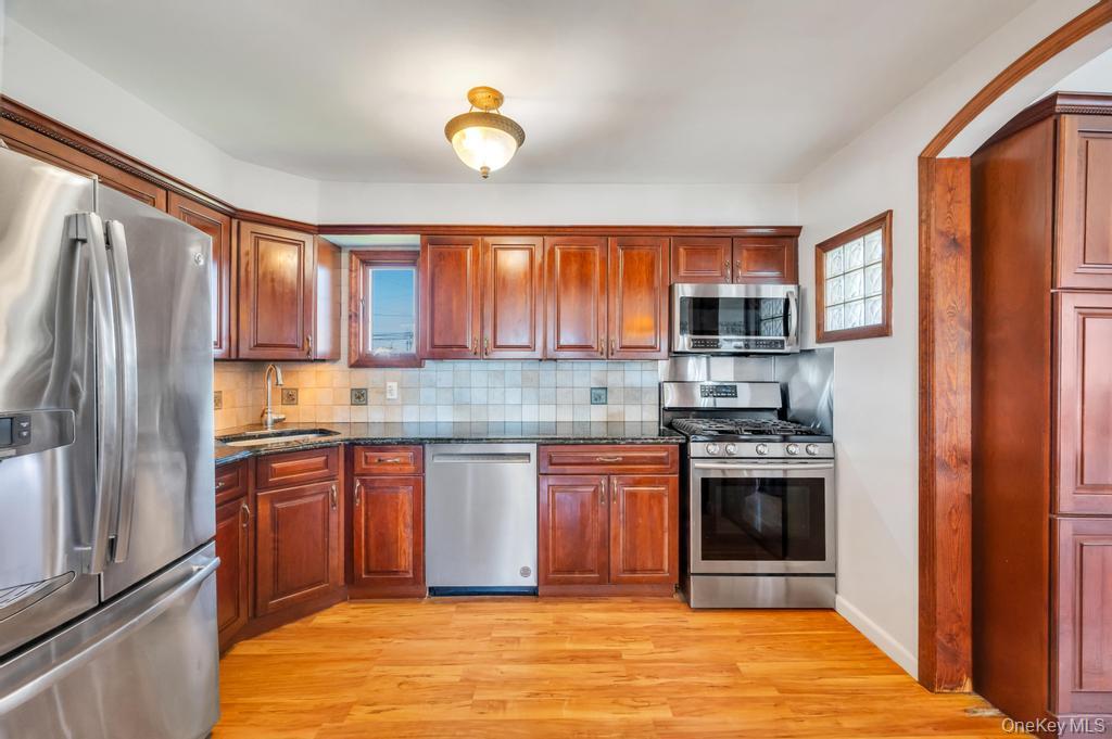 398 33rd Street Lindenhurst, NY 11757 - Photo 20 of 44 a kitchen with stainless steel appliances granite countertop a stove a sink and a refrigerator