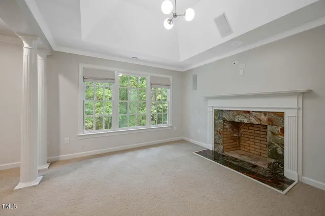 a view of an empty room with a fireplace and a window
