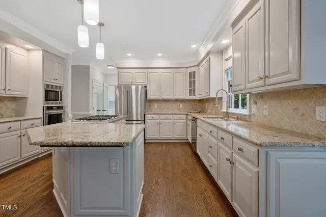 a kitchen with stainless steel appliances granite countertop a sink stove and cabinets