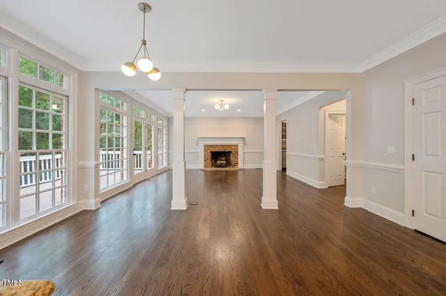 a view of a big room with wooden floor fireplace and windows